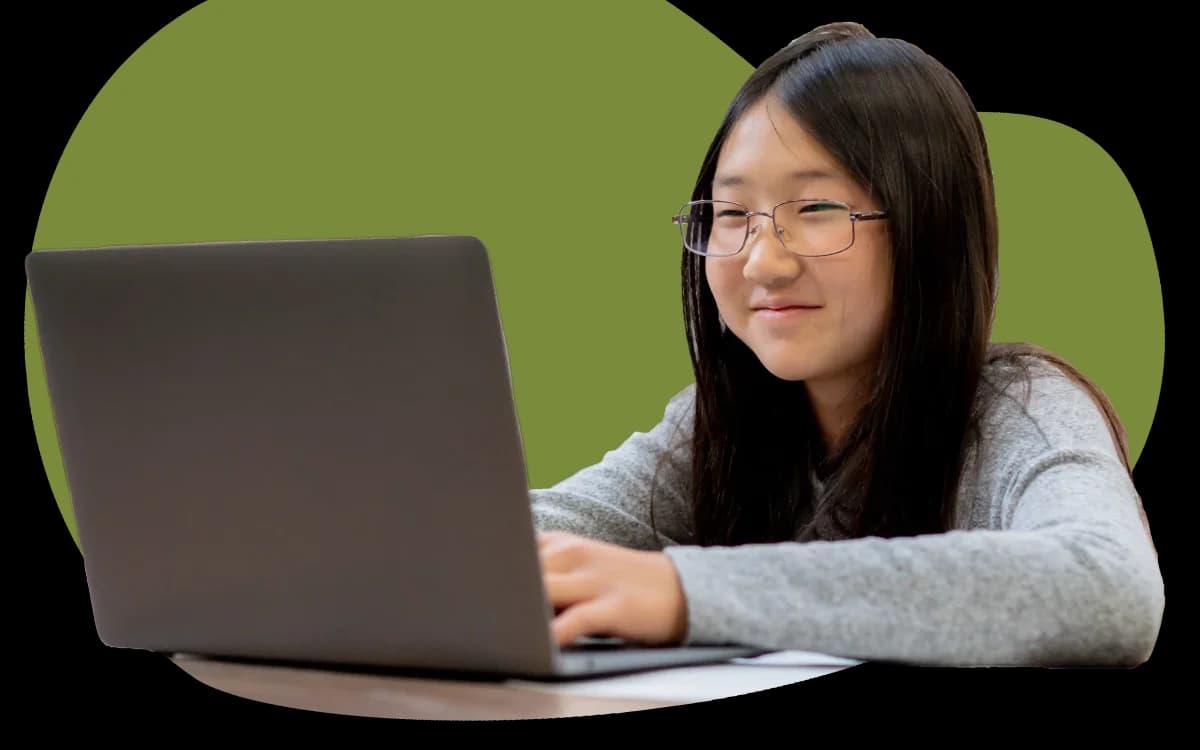 Student smiling at a laptop
