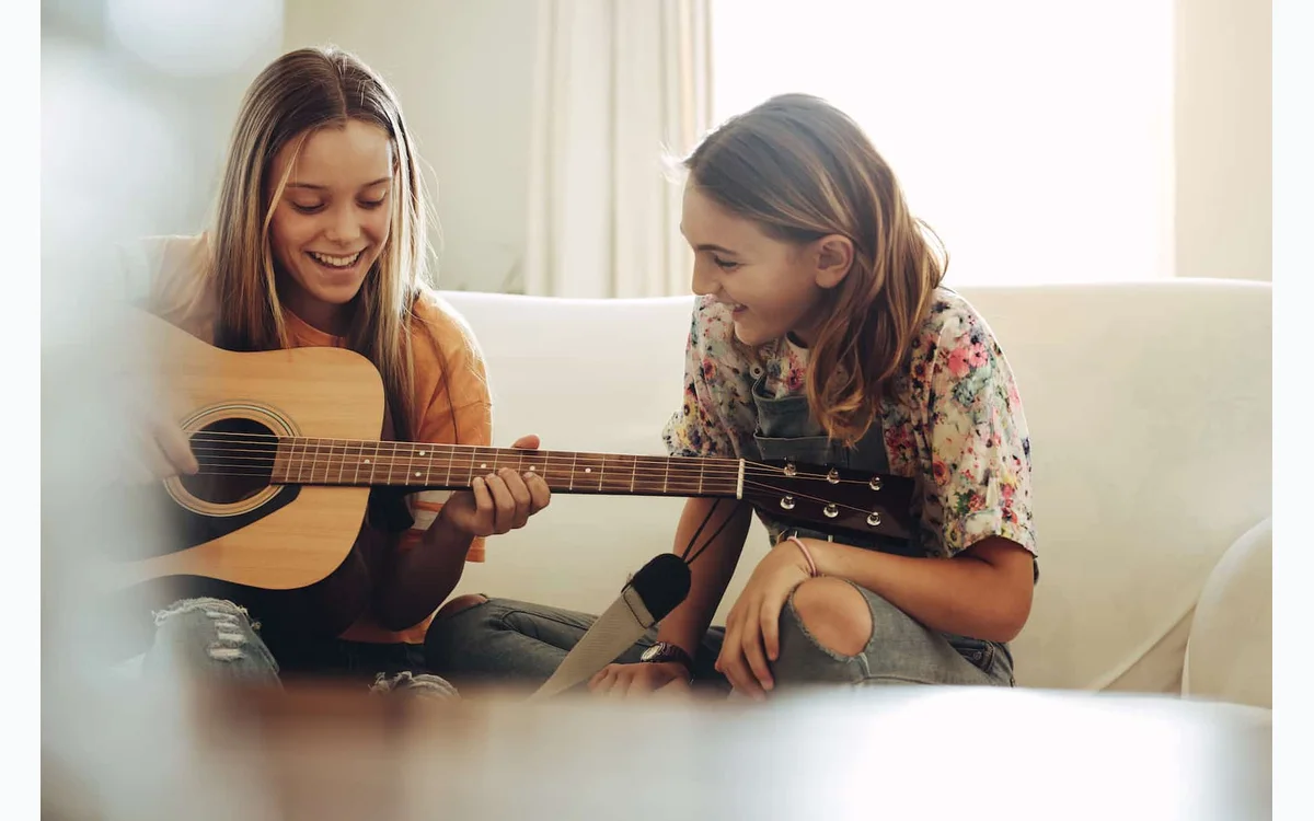 Two students learning guitar with Moosiko